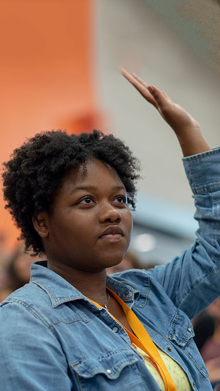 A student raising their hand to ask a question