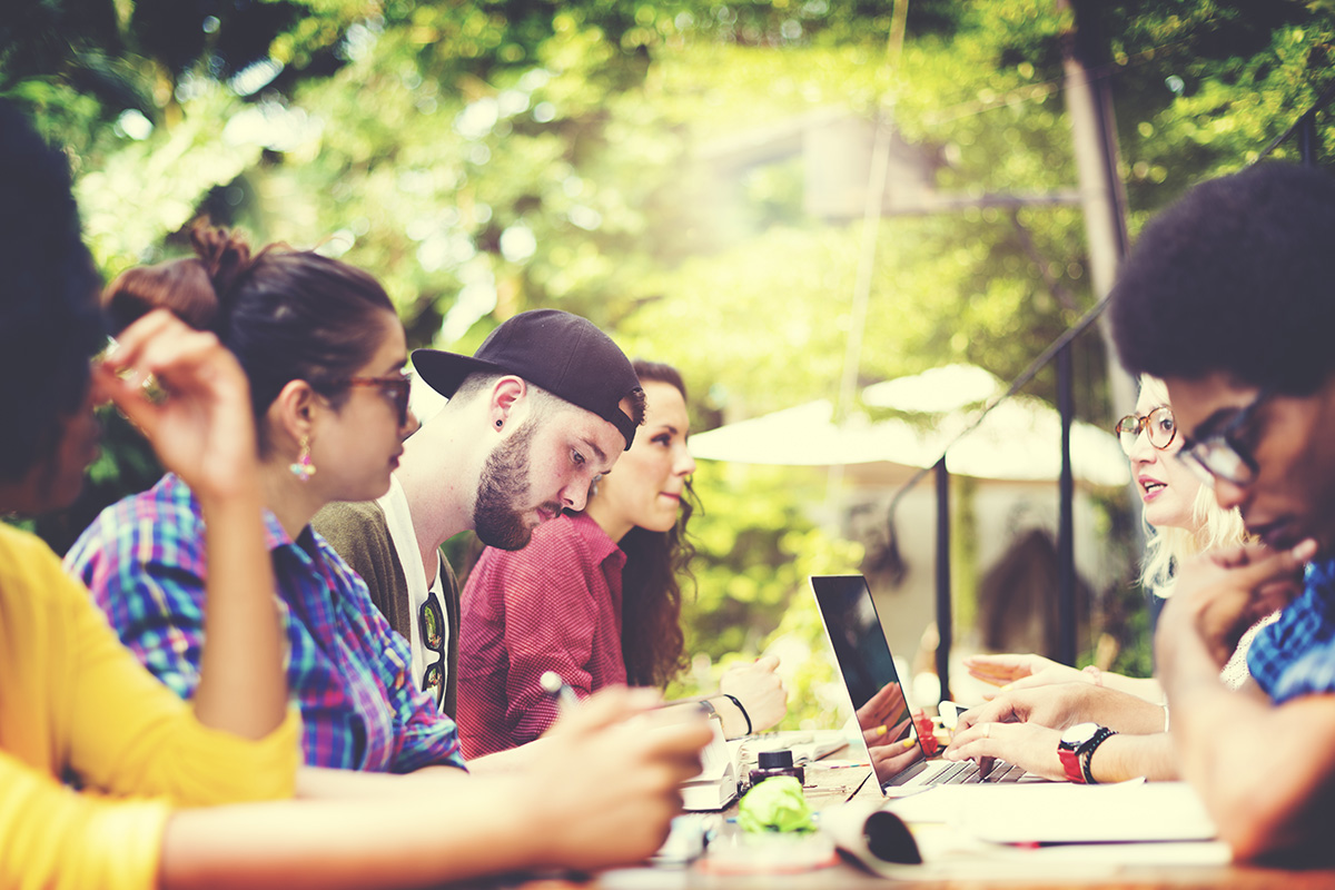 diverse group of students collaborating outside on a sunny warm day