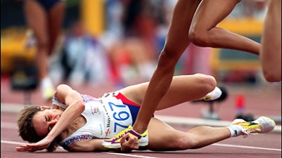 A runner who fell over gets trampled by a fellow competitor.