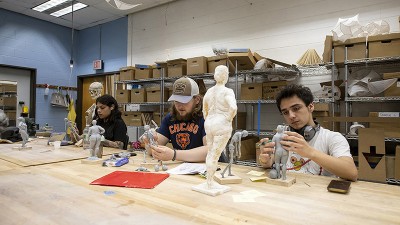 Students work on sculpting in a studio.