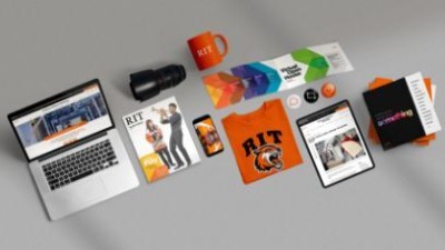 A laptop showing the R I T homepage next to an assortment of other R I T marketing material.