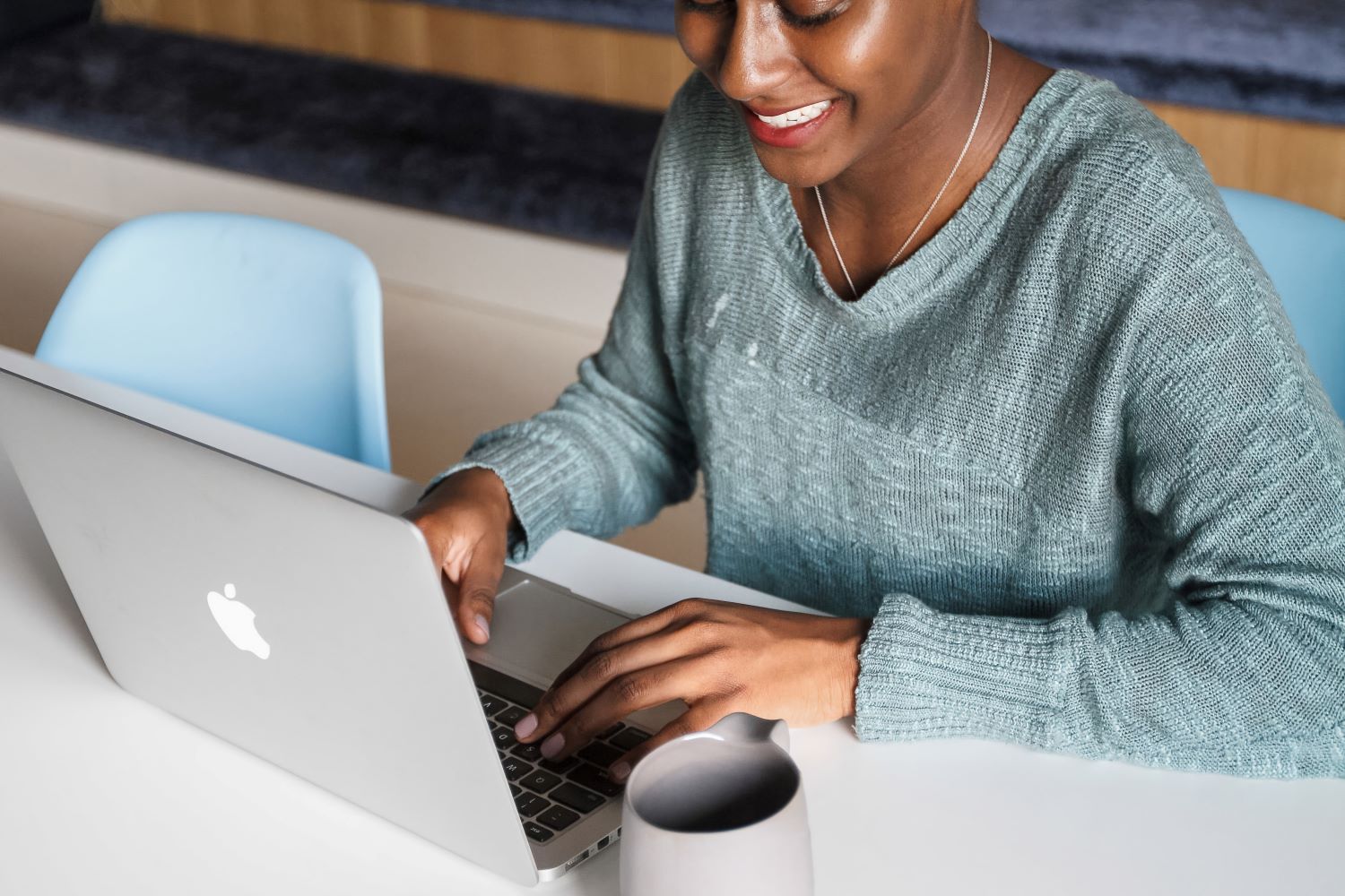 woman smiling and looking at a laptop