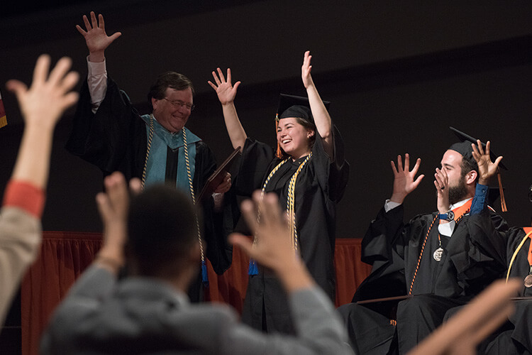 A student smiling while graduating.