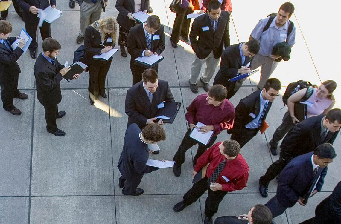 A group of students in business attire waiting in line for the career fair
