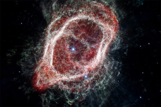 a colorful 3 D image of the southern ring nebula appears in a black sky.